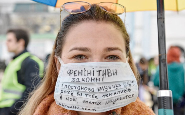 фото, девушка в маске с призывом к употреблению феминитивов