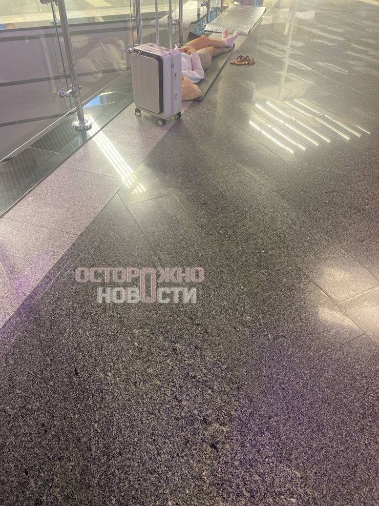 фото пасажира, який спить на підлозі в аерпорту Сочі