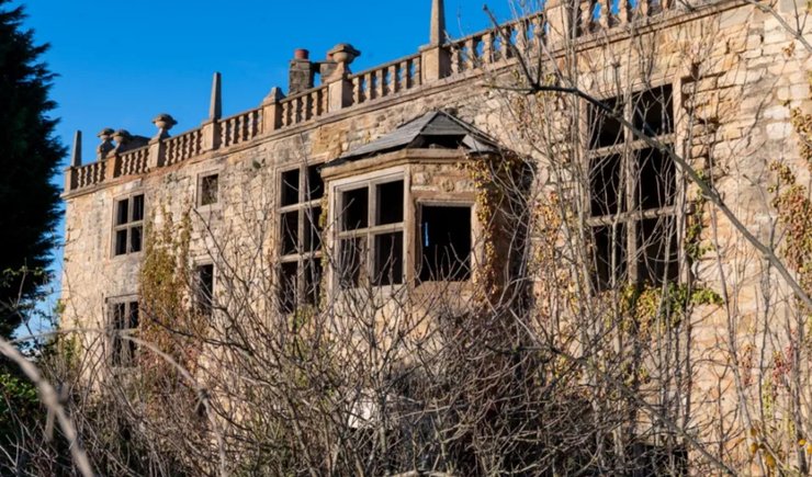 Зруйнований будинок XVII століття, оброслий плющем, з проломленими стінами і вибитими вікнами