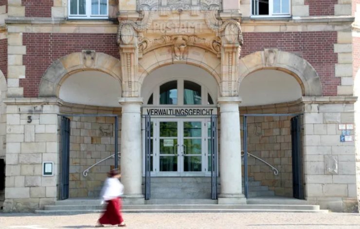 Вход в административный суд Германии, перед которым проходит женщина