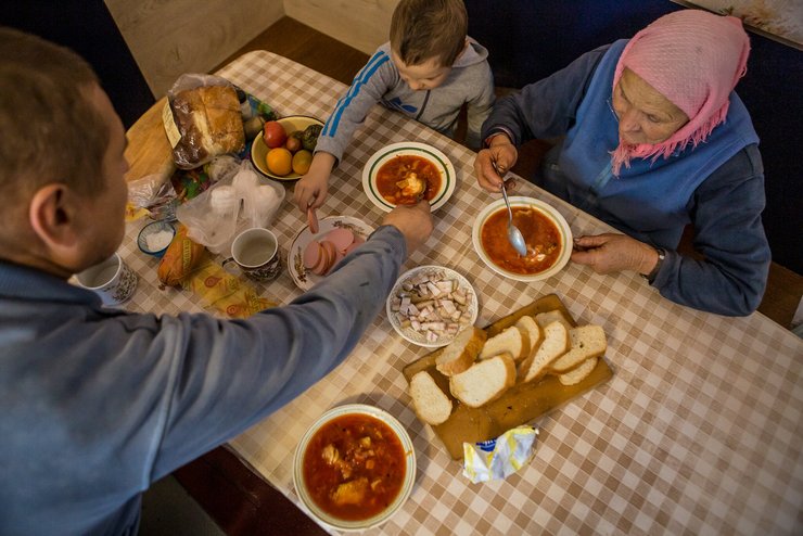 Семья за столов в селе Борщев, Украина/Фото: The New York Times