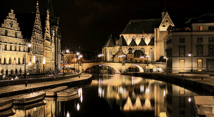 Ночной вид на центр Гента с каналом, старинным мостом и подсвеченной средневековой архитектурой в Бельгии