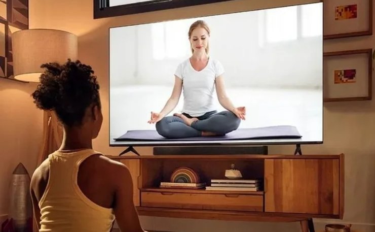 Дівчина займається йогою перед телевізором Vizio VFD32M-0807