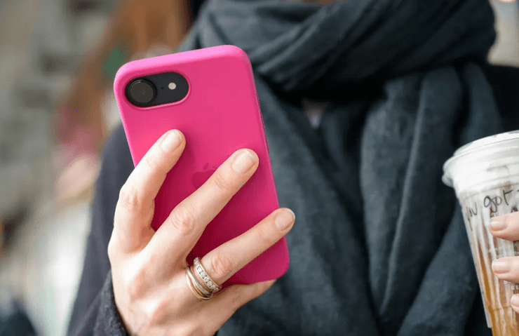 Мужчина держит смартфон iPhone 16e