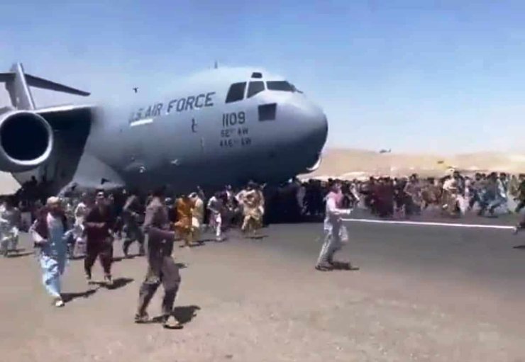 Афганцы, отчаянно преследующих реактивный самолет ВВС США вдоль взлетно-посадочной полосы в аэропорту Кабула.