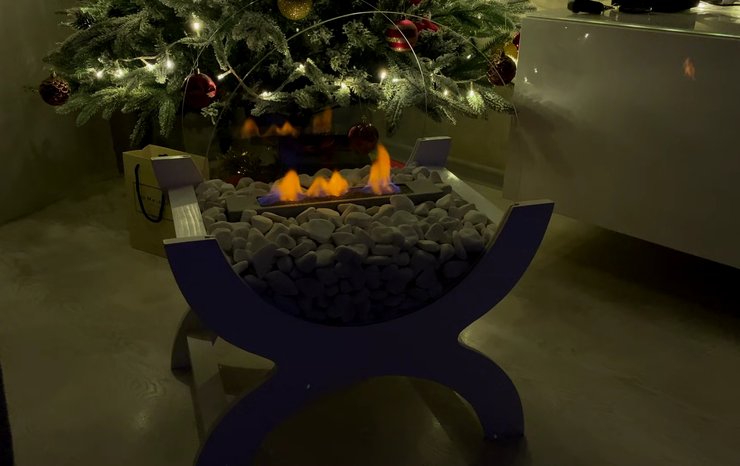 Біокамін горить перед новорічною ялинкою під час вимкнення світла