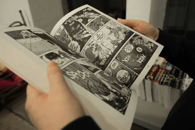 Крупный план рук, держащих книгу с комиксами