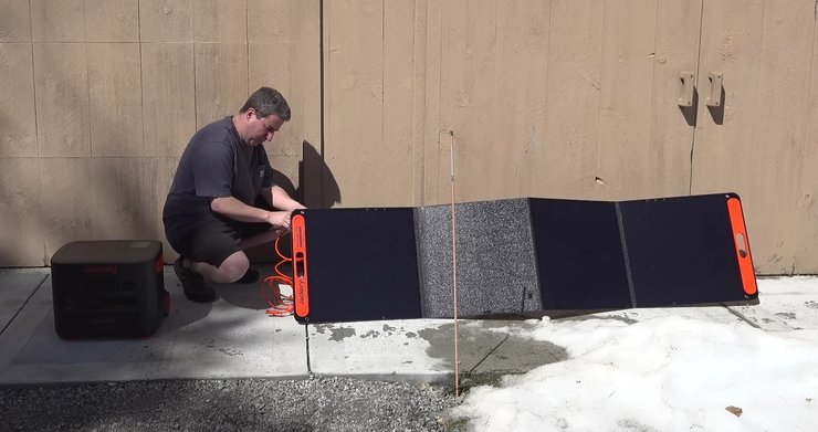 Мужчина устанавливает солнечный Jackery Explorer 3000 Pro во дворе дома