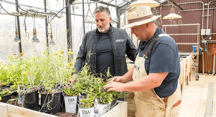 Джейсън Орвис и служител на оранжерия проверяват отглеждането на растения в самостоятелно съоръжение.