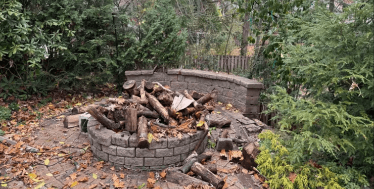 Зруйноване патіо і купа спиляних колод, що залишилися після незаконного знесення дерев сусідами