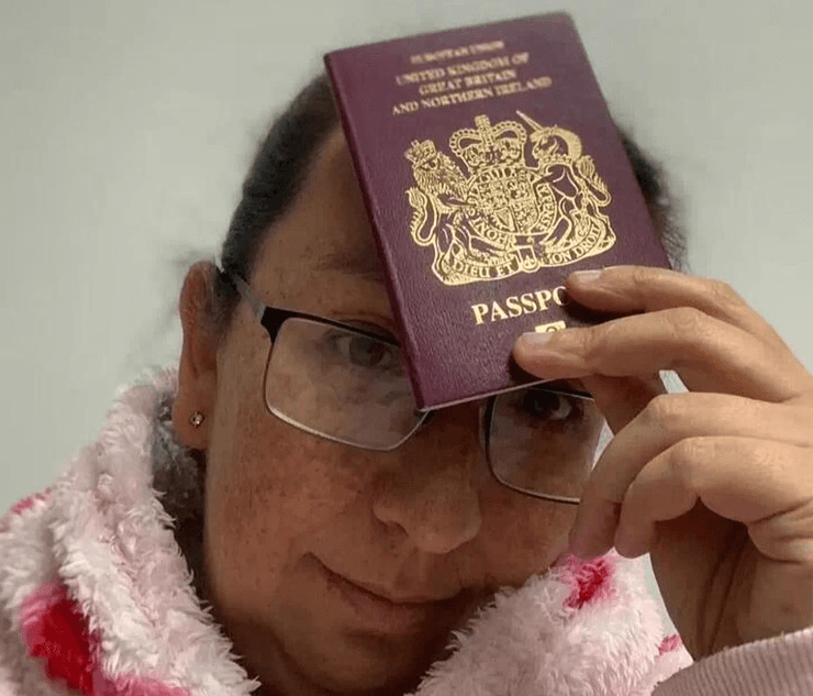 Жінка тримає британський паспорт біля чола після того, як дізналася, що не зможе полетіти з родиною
