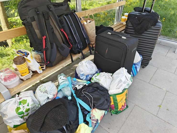 Две украинские беженки держат свои вещи на неработающей автобусной остановке в Варшаве