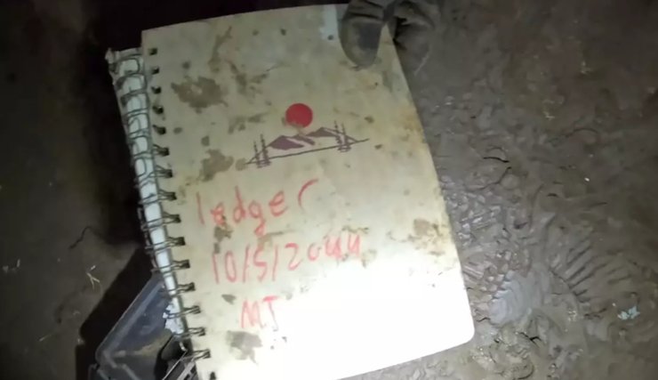 Старий брудний блокнот, що лежить на підлозі печери "Hell Hole", куди відвідувачі залишають записи