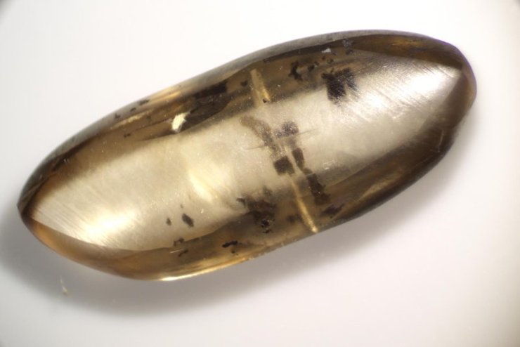 Детальное фото продолговатого прозрачного камня с вкраплениями