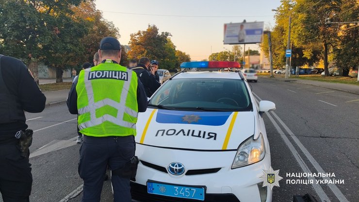 Патрульные полицейские работают на дороге после обнаружения тела мужчины с множественными огнестрельными ранениями; рядом стоит автомобиль Chevrolet