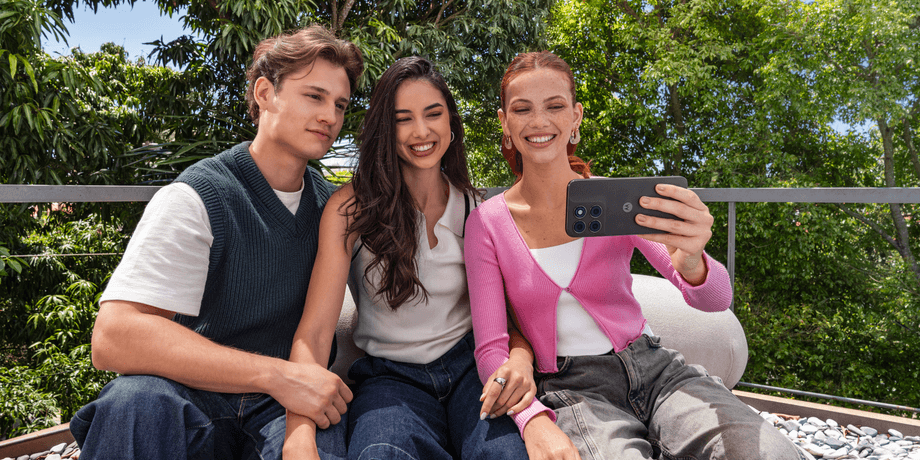 Компанія фотографується зі смартфоном Moto G77