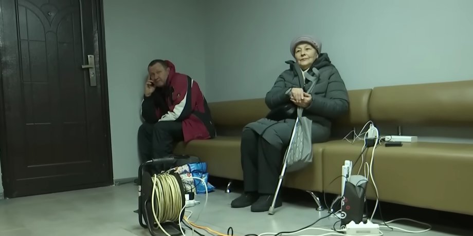 Мужчина и женщина во время блэкаута заряжают гаджеты во время блэкаута