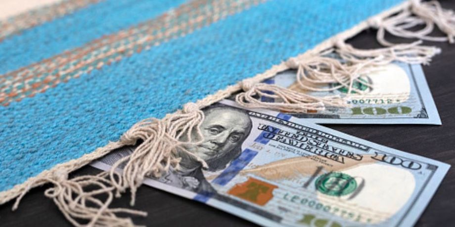 Две купюры по 100 долларов под ковром