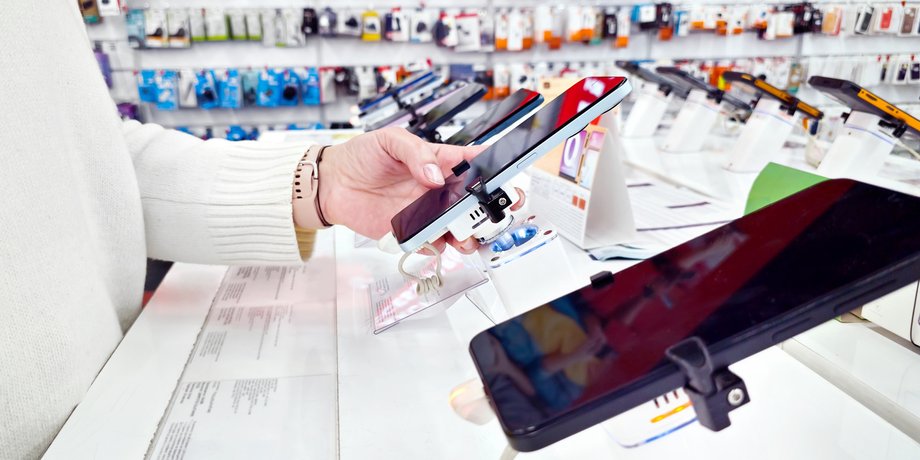 Дівчина оглядає смартфон у магазині