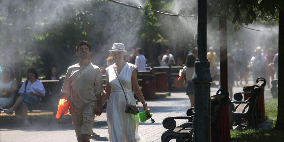Люди гуляют в парке во время летней жары в Украине