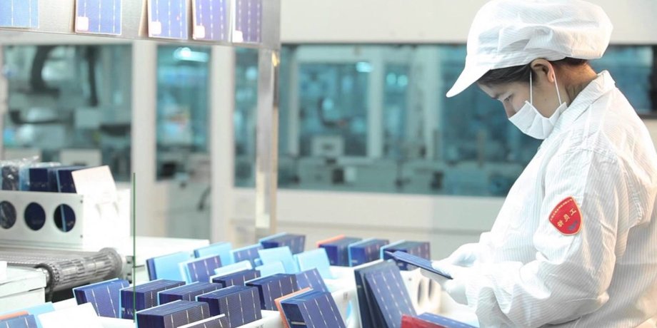 Сотрудник Jinko Solar делает солнечные панели