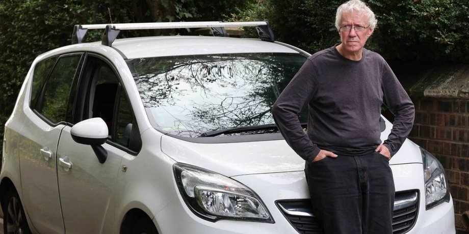 63-річний Майкл Аткінсон стоїть біля свого автомобіля Vauxhall Meriva, який став його домом