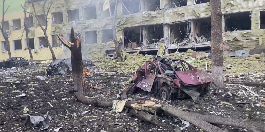 зруйнована будівля, згорілі машини
