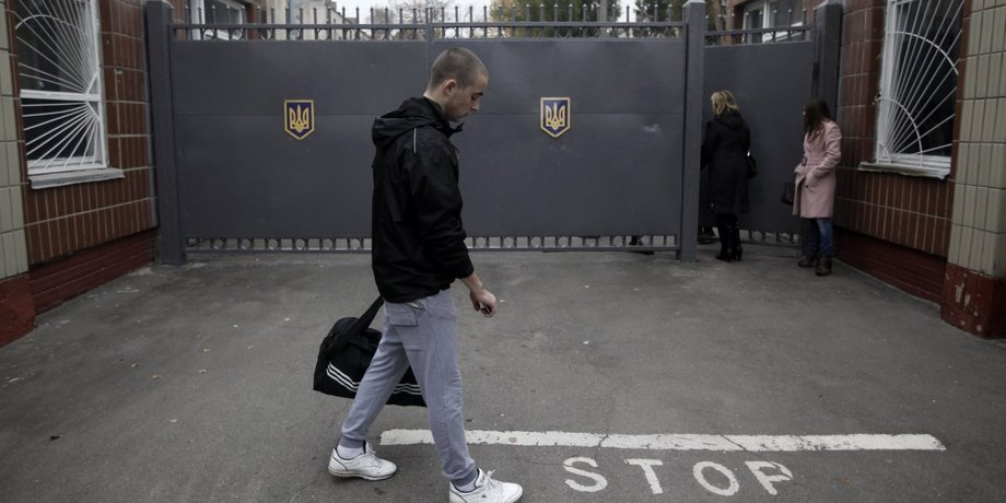 Изображение военнообязанного мужчины возле воинской части