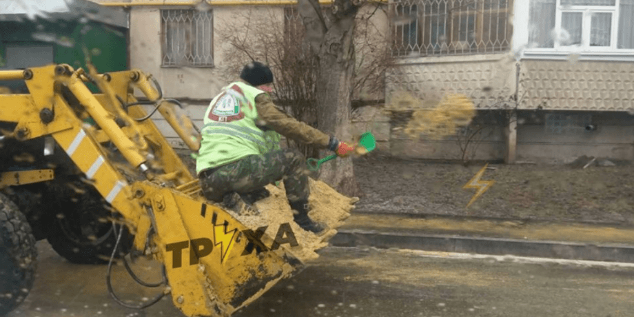 Харьковский "коммунальщик" посыпает дорогу песком из детской лопатки, гололед, Харьков, гололед в Харькове