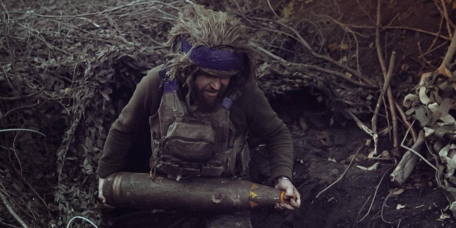 Військовий ЗСУ з артилерійським снарядом
