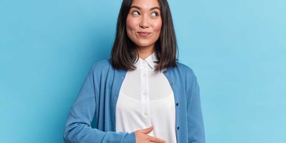 Дівчина тримає руку на животі