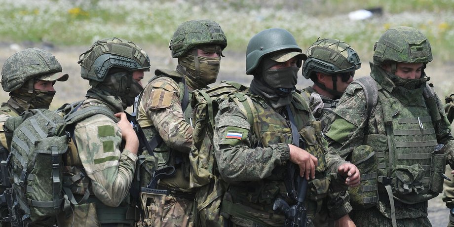 группа российских военных стоит посреди поля