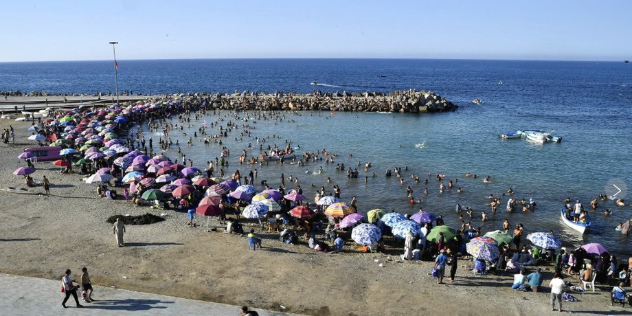Чоловіки відпочивають біля моря після скасування заборони на шорти-бермуди