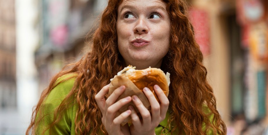 Девушка держит в руках бургер