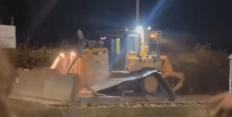 Нічний кадр із бульдозером, який викрав чоловік і проїхав вулицями міста, руйнуючи автомобілі та майно