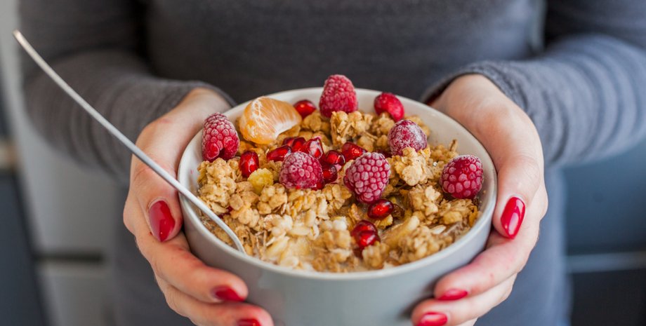 жінка тримає миску вівсянки в руках