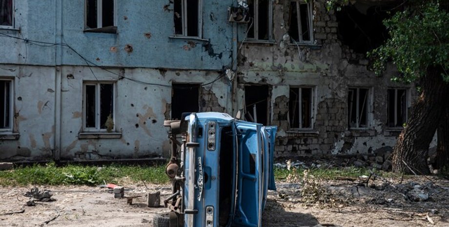 Автомобиль на фоне разрушенного здания в Лисичанске.