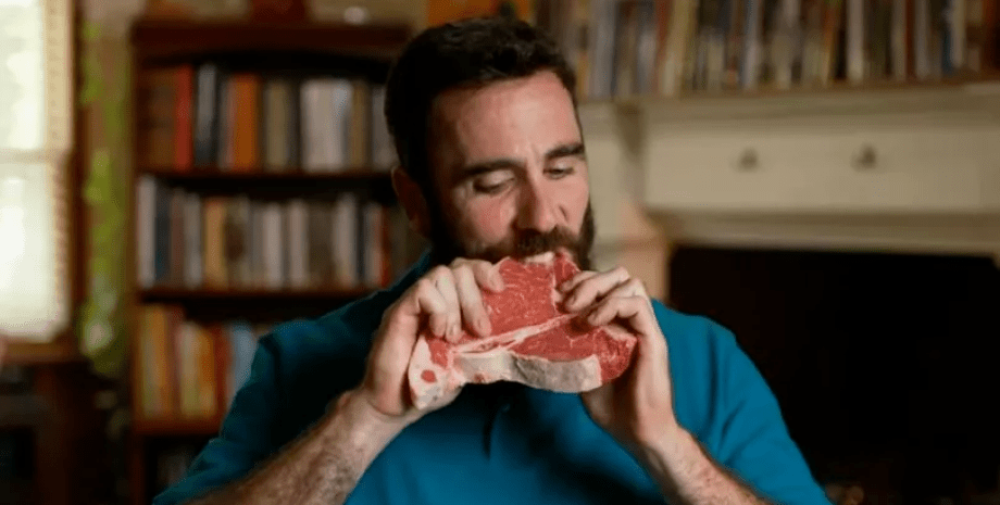 Чоловік їсть сире м'ясо, особлива дієта, небезпечно для здоров'я, ризикує життям, неприготоване м'ясо, м'ясо, червоне м'ясо