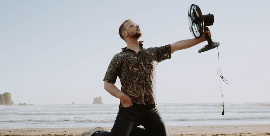 мужчина с вентилятором на пляже жара, пляж, охлаждение