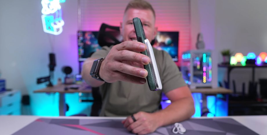 Мужчина демонстрирует смартфон с павербанком Anker Nano Slim