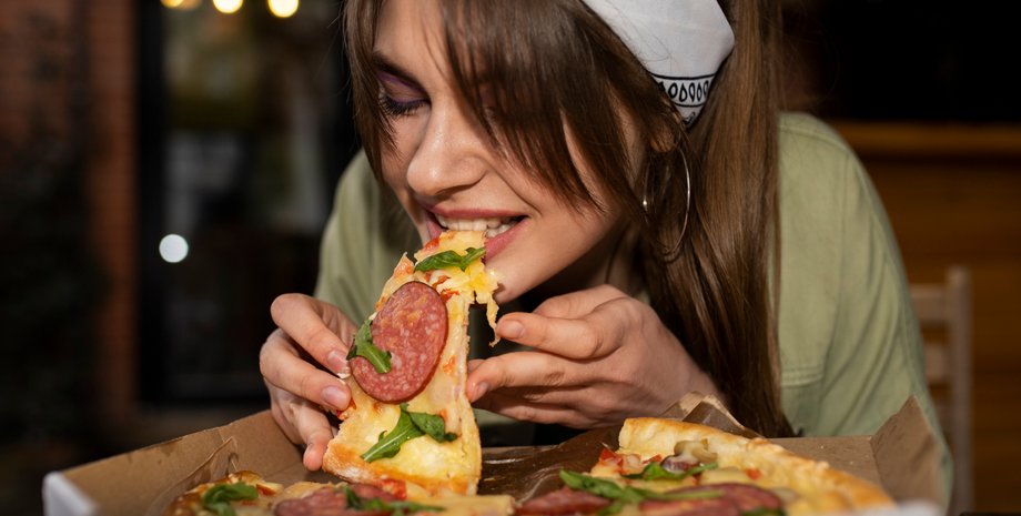 Девушка ест пиццу