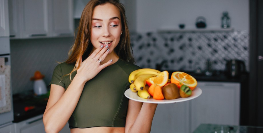 Красивая девушка держит тарелку фруктов