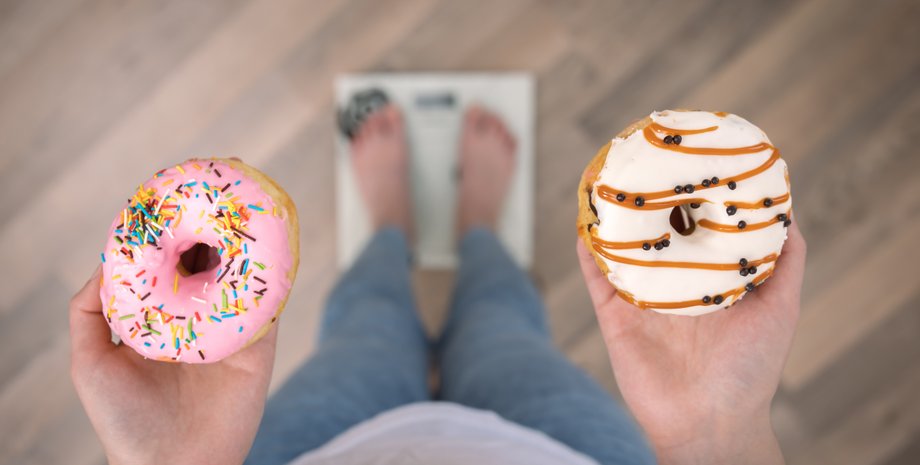 Дівчина тримає пончики