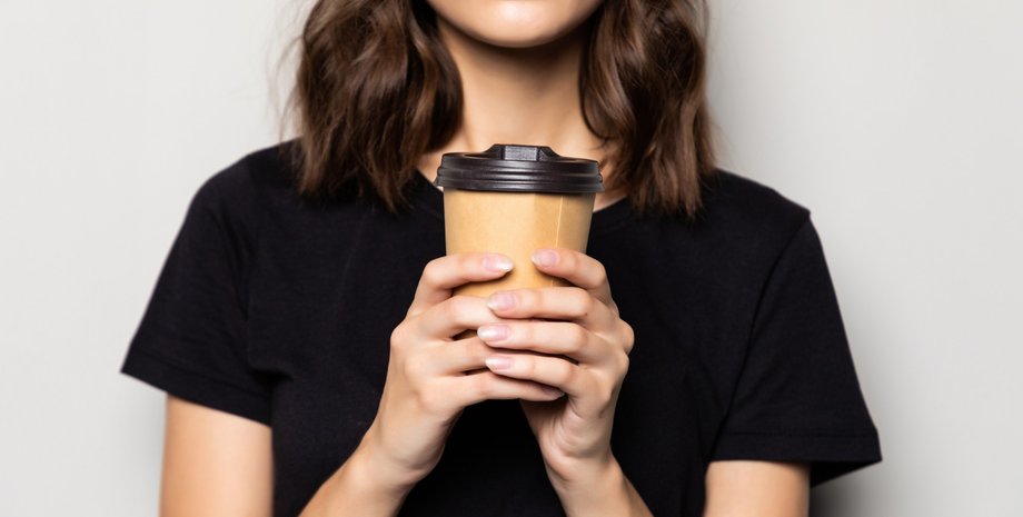 Девушка держит стакан кофе