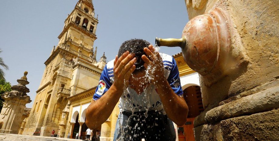 Мужчина умывается на улице из-за жары