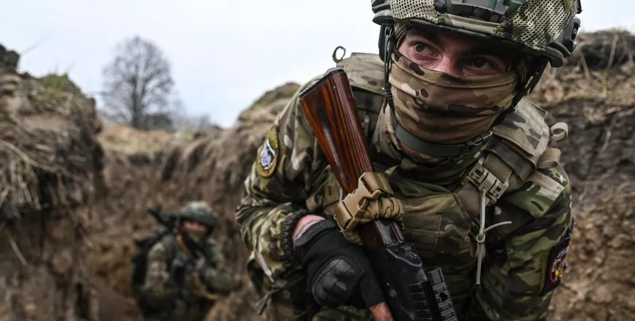 Російський військовий Російський військовий в масці та з автоматом