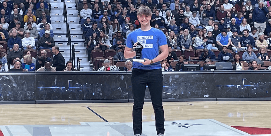 Молодий мільярдер і співзасновник Mercor Брендан Фуді стоїть на арені з нагородою в руках перед великою аудиторією