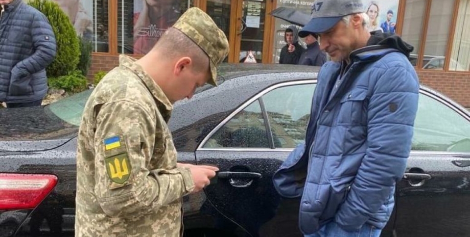 вручение повестки в украине, представитель тцк выписывает повестку в украине, мужчине вручают повестку