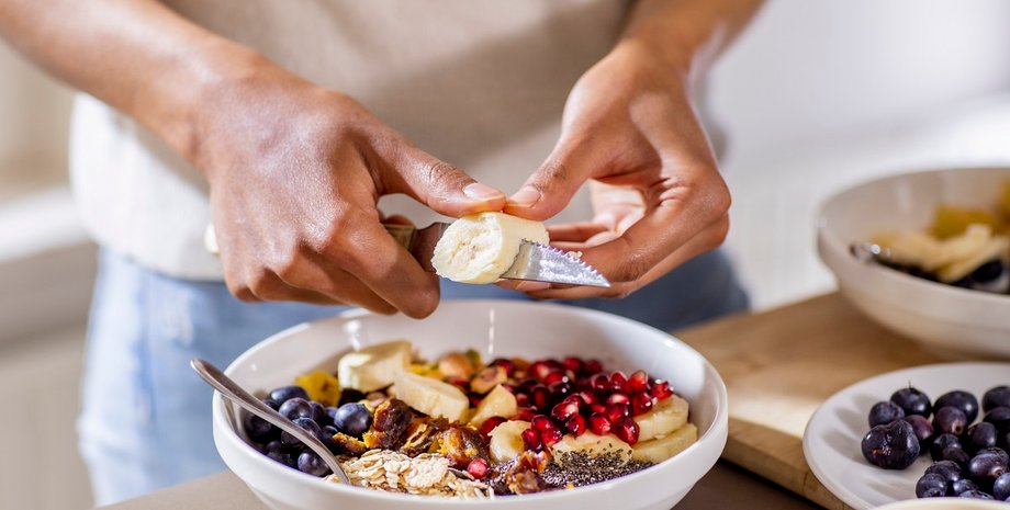 Девушка режет банан в овсянку