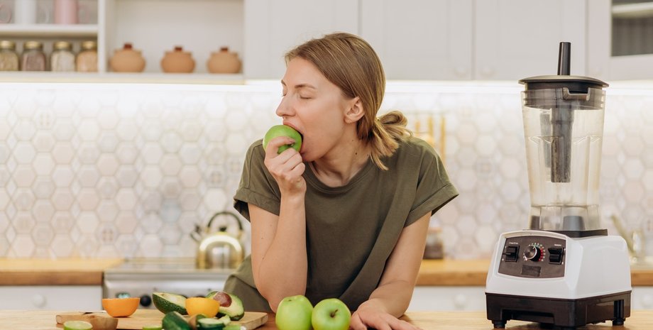 Дівчина їсть яблуко